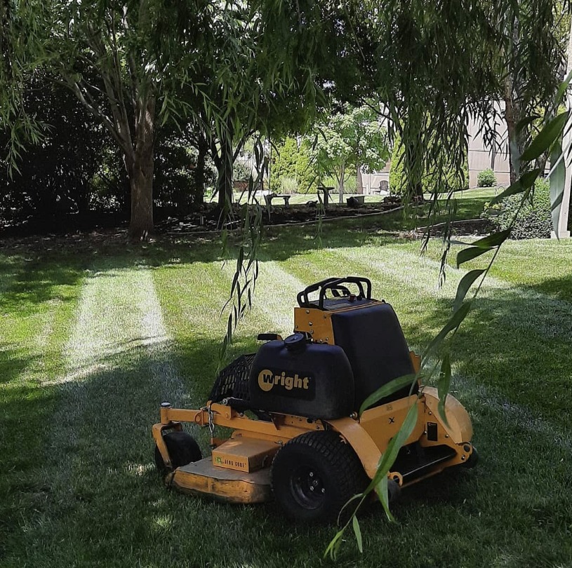 A picture of a well-manicured lawn with evenly cut grass, showcasing the results of professional lawn mowing services. The image captures the beauty and neatness of a perfectly mowed lawn, inviting viewers to experience the same for their own yard.